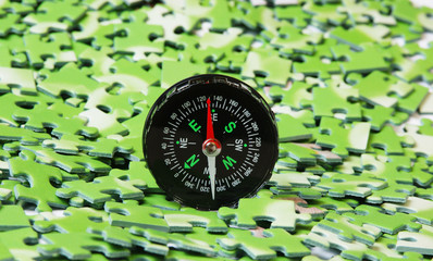 compass on pile of green puzzle