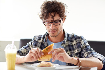 happy man eating sandwich at cafe for lunch