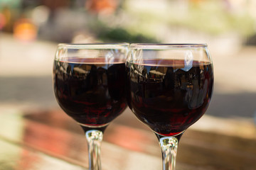 glasses with red wine on a table at an outdoor cafe with a blurr