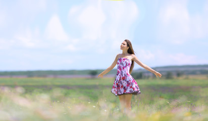 Fototapeta na wymiar Pretty girl posing on lavender field, looking fresh and happy