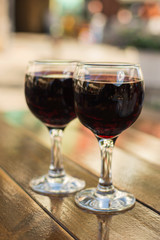 glasses with red wine on a table at an outdoor cafe with a blurr