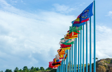Regional flags of Spain in the wind over long blue poles