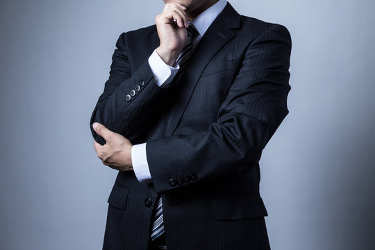 スーツを着ているビジネスマン、考える