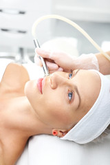 Dermabrazja diamentowa, złuszczający peeling naskórka. kobieta podczas zabiegu mikrodermabrazji  w salonie kosmetycznym