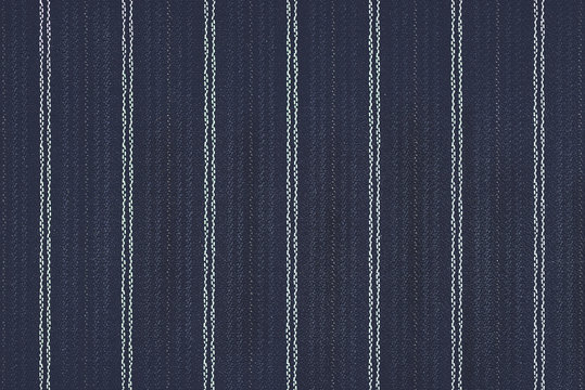Close up of pinstriped fabric texture background.Detail of navy blue wool suiting with twin white pinstriped