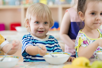 children eating from plates in day care centre