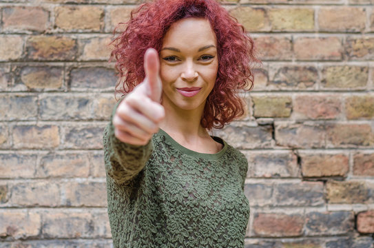 Cute young half-caste showing ok sign with thumb