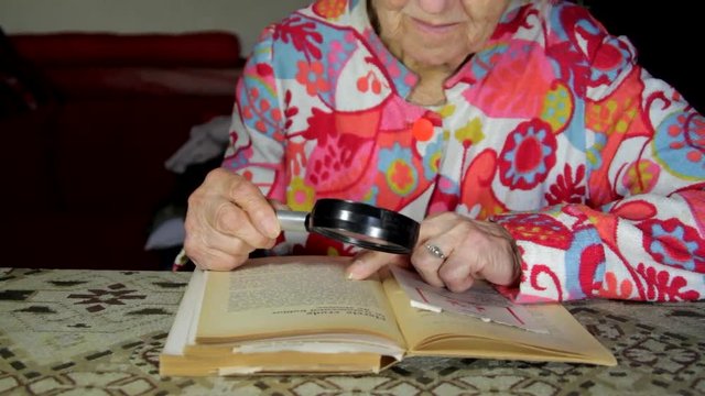 Very Old Lady Reading A Book With A Magnifying Glass, Poor Vision, Tilt