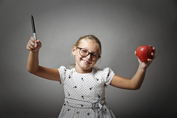 Bambina sorridente con la mela in mano - obrazy, fototapety, plakaty