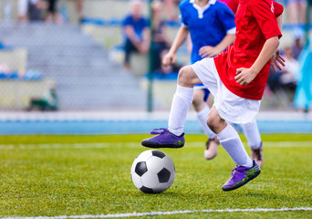 Young boys playing soccer match. Kids kicking football on sports field