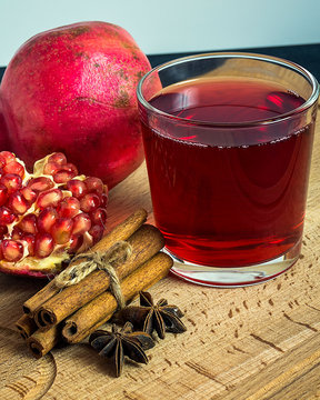 star anice, cinnamon and pomegranate tea on wooden table. Vertical