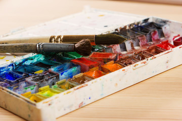 artists brushes and watercolour paints on palette. Vintage styli