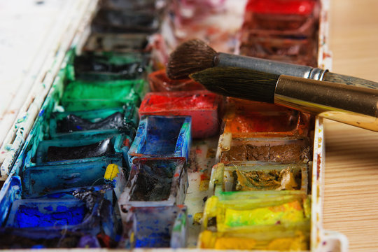 artists brushes and watercolour paints on palette