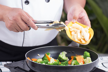 Chef putting baby corn to pan