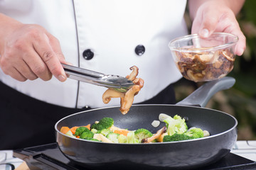 Chef putting mushroom to pan
