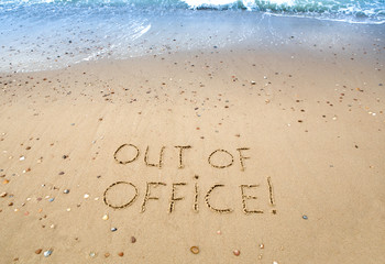 out of officek, written in the sand at the beach