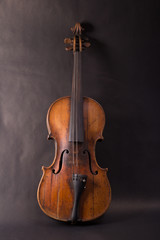 Fototapeta na wymiar Old broken violin on black background