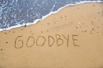 goodbye, written in the sand at the coast