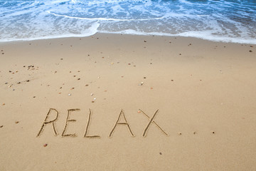 relax, written in the sand at the beach