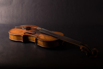 Naklejka na ściany i meble Old broken violin on black background