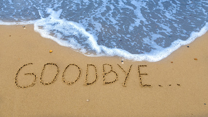 goodbye, written in the sand at the beach