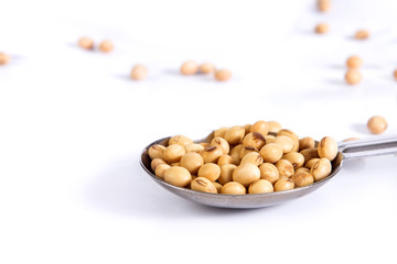 Group of Steel measuring spoons and soybean  on white background
