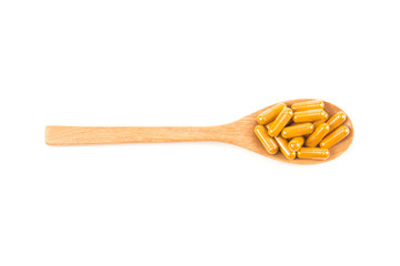 Close up turmeric capsule in spoon on white background