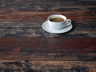 White cup of coffee on wooden old boards