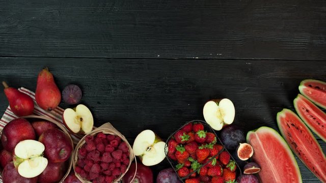 Fruits stop motion animation with copy space 4k intro video background. Red purple healthy fresh food moving on black table
