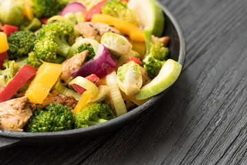 Roasted meat and vegetables on a black wooden background