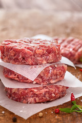 Raw Ground beef meat Burger patties at picnic table 