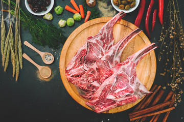 Raw triple tomahawk beef steak. with ingredients for grilling with a spice rub, fresh rosemary on...