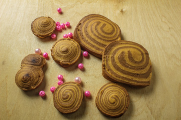 homemade cookies spiral with beads on a light wooden background