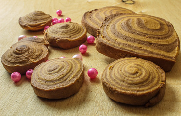 homemade cookies spiral with beads on a light wooden background