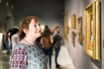 closeup on attentive senior woman visiting museum and enjoying a - obrazy, fototapety, plakaty