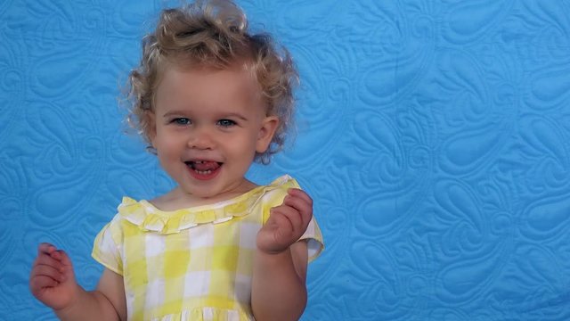 Emotional toddler girl play-act simper looking at camera.