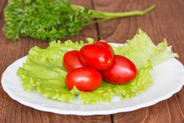 Помидоры и листья салата на тарелке