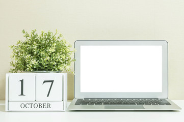 White wooden calendar with black 17 october word with white blank space at center of computer...