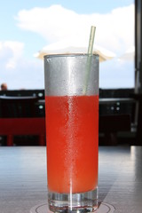 холодный вкусный красный коктейль Маргарита в высоком стакане с трубочкой