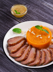 Roast duck breast and pumpkin mash, served with mint and pine nuts. Slices of duck with sweet butter squash, mustard and honey sauce