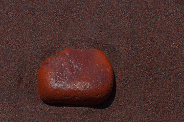 red stone on sand of Red Beach on Santorini