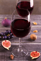 Glasses and bottle red  wine with lavender, pesto cheese and grape on chopping board. Wine and food still life in warm tones