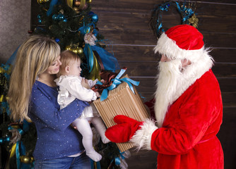 Fototapeta na wymiar Santa gives a gift to mum with baby