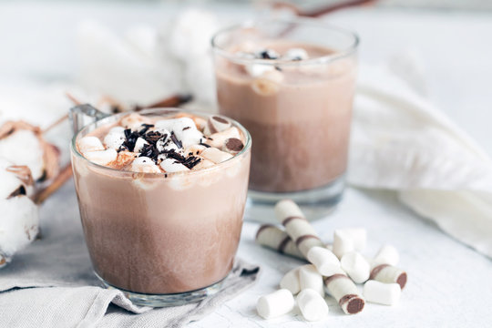 Two glass cups of hot cocoa served with marshmallow – close up