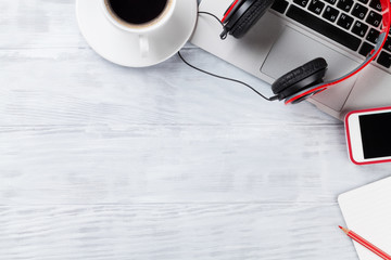 Desk table with laptop, coffee and headphones