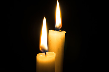 Two burning candles on black background. Copyspace