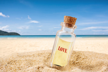 love text on paper in bottle over tropical sand beach with clear blue sky background for love travel on vacation summer concept.