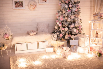 Christmas children room with decoreted shabby chic style new year tree and gift boxes under it. Light bulbs garland on the carpet. Holiday background