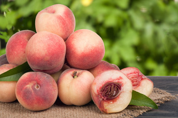 heap of peaches on a wooden table with blurred background