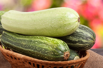 green zucchini and courgettes on sackcloth with a blurred background